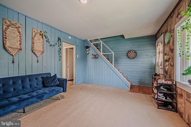 carpeted living room with wood walls