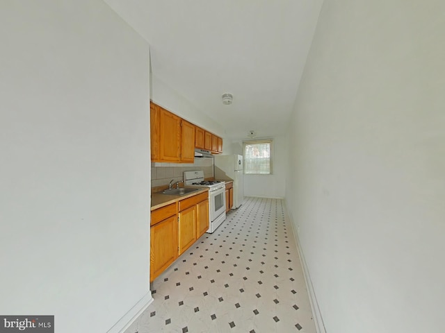 kitchen with decorative backsplash, sink, exhaust hood, and white appliances