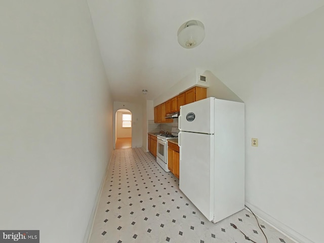 kitchen with vaulted ceiling and white appliances