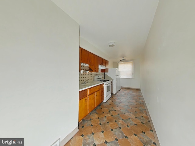 kitchen featuring white appliances, tasteful backsplash, and sink