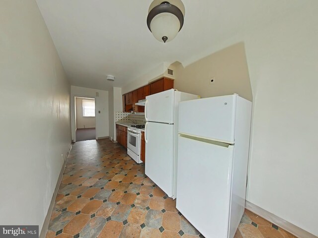 kitchen featuring backsplash and white appliances