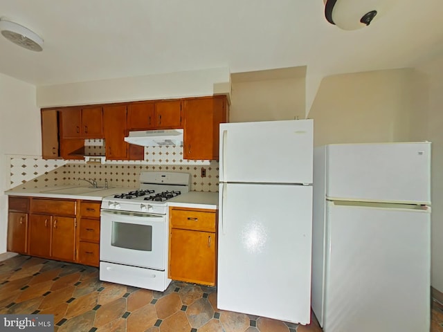 kitchen featuring backsplash, white appliances, and sink