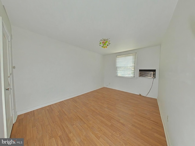 empty room with light hardwood / wood-style flooring and a wall mounted AC