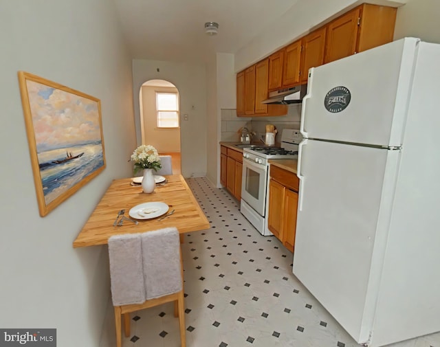 kitchen with white appliances and backsplash