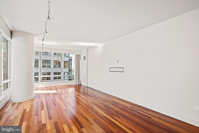 empty room with decorative columns and hardwood / wood-style floors