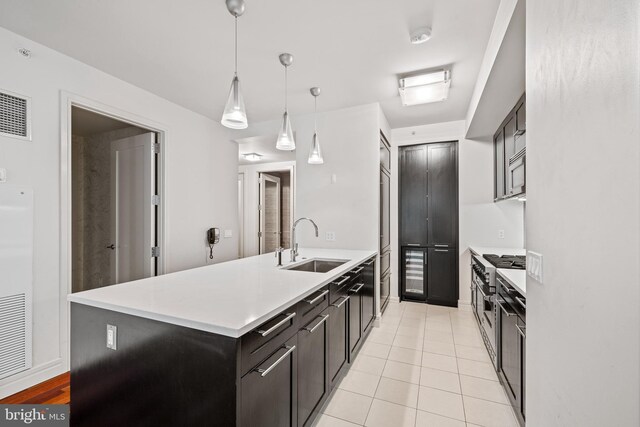 kitchen with a kitchen island, sink, light tile patterned floors, and pendant lighting