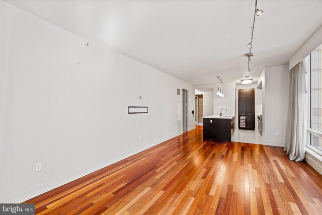 unfurnished living room with light wood-type flooring and sink