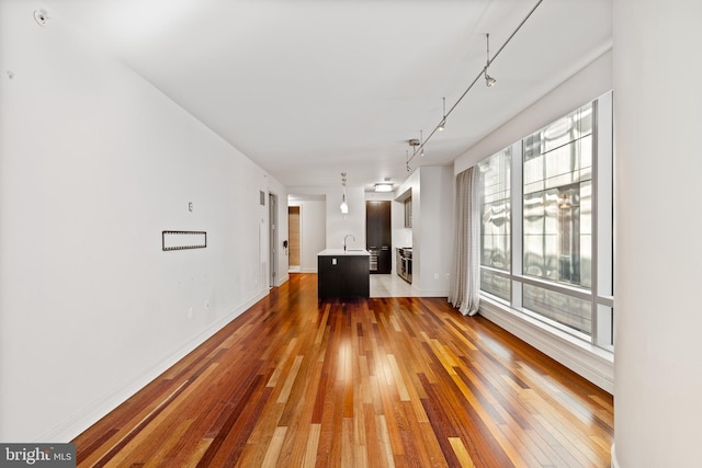 interior space featuring hardwood / wood-style flooring, sink, and track lighting