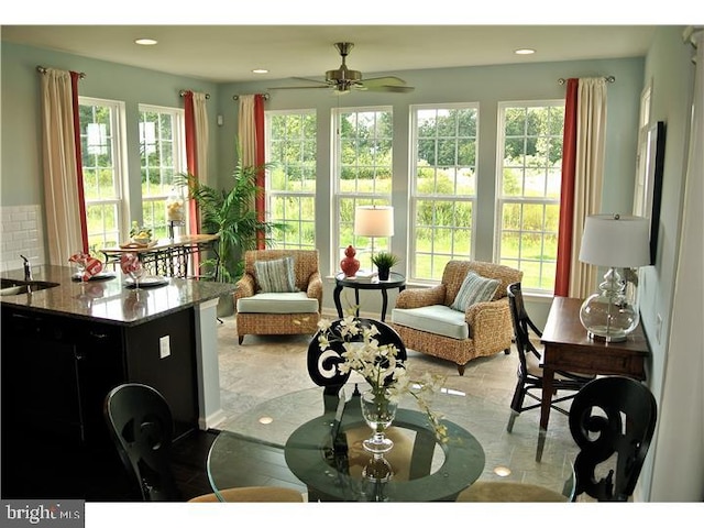 living room with plenty of natural light, ceiling fan, and sink