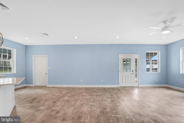 unfurnished living room with ceiling fan and light hardwood / wood-style flooring