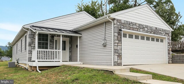 view of front facade with an outbuilding, cooling unit, and a garage