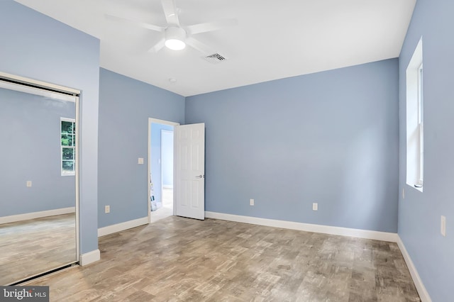 empty room with ceiling fan and light hardwood / wood-style flooring