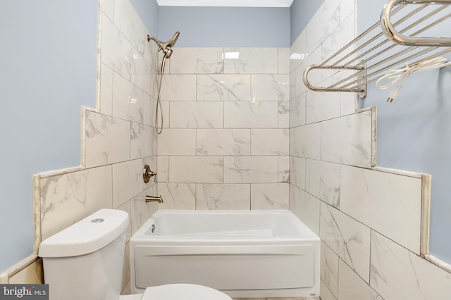 bathroom with tile walls, tiled shower / bath, and toilet