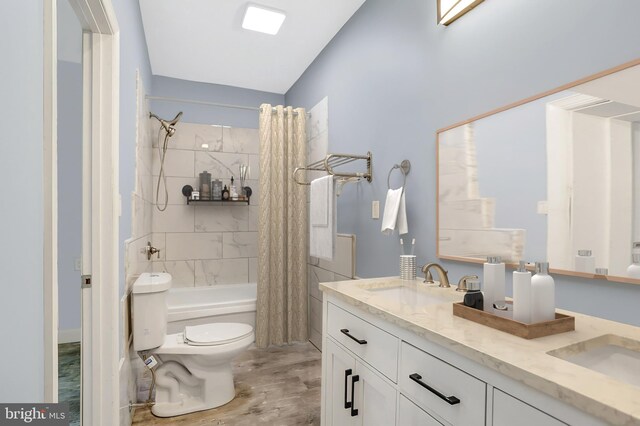 full bathroom with wood-type flooring, shower / tub combo, double vanity, and toilet