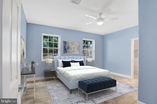 bedroom with multiple windows, ceiling fan, and light hardwood / wood-style flooring