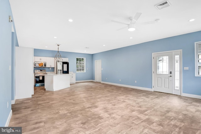 unfurnished living room featuring ceiling fan and light hardwood / wood-style floors