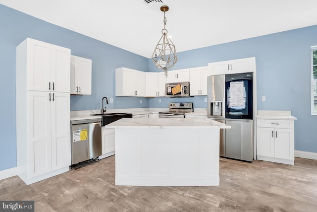 kitchen featuring pendant lighting, white cabinetry, sink, a center island, and stainless steel appliances