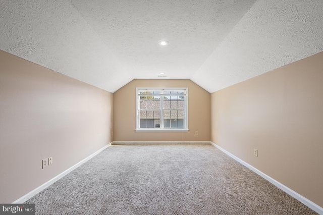 bonus room with vaulted ceiling, a textured ceiling, and carpet floors