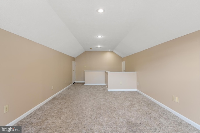 additional living space with vaulted ceiling and light colored carpet