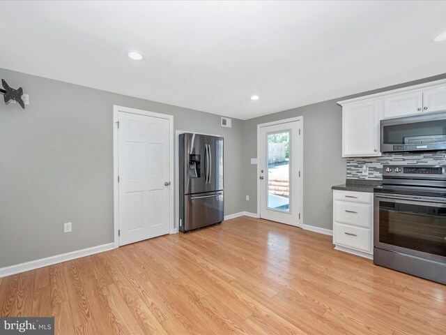 kitchen featuring tasteful backsplash, white cabinetry, appliances with stainless steel finishes, and light wood-type flooring