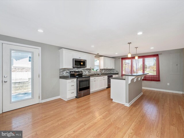 kitchen with pendant lighting, appliances with stainless steel finishes, a kitchen bar, and white cabinets