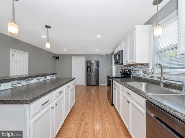 kitchen featuring appliances with stainless steel finishes, sink, hanging light fixtures, and white cabinets