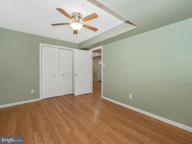 unfurnished bedroom with ceiling fan, light hardwood / wood-style floors, and a closet