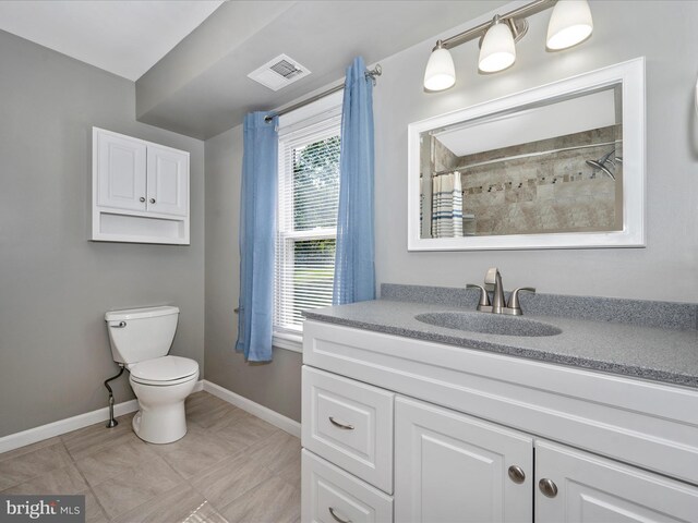 bathroom with vanity, tile patterned flooring, toilet, and walk in shower