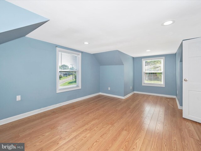 additional living space featuring light hardwood / wood-style flooring and vaulted ceiling