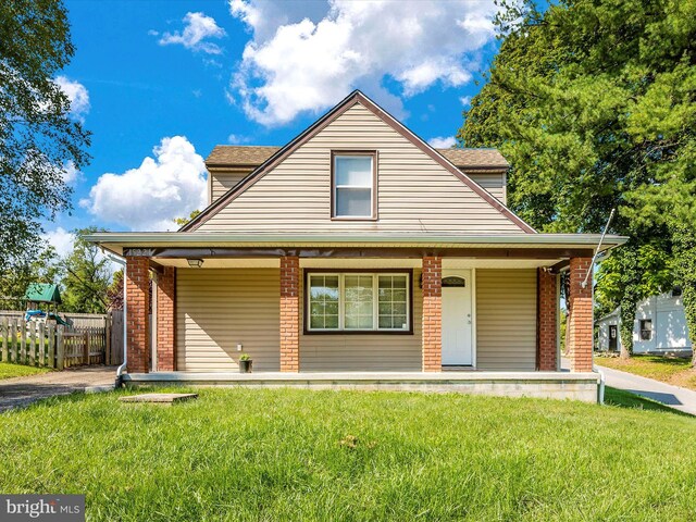 bungalow-style home featuring covered porch and a front lawn