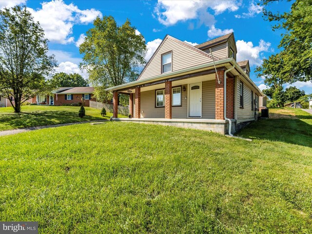 view of front of property featuring central AC, a porch, and a front lawn