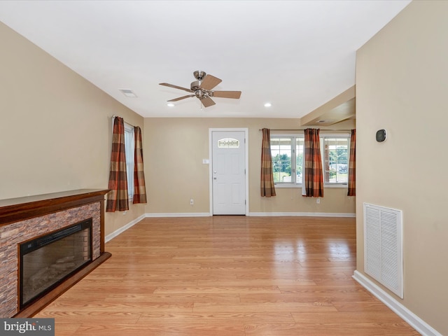 unfurnished living room with a fireplace, light hardwood / wood-style floors, and ceiling fan