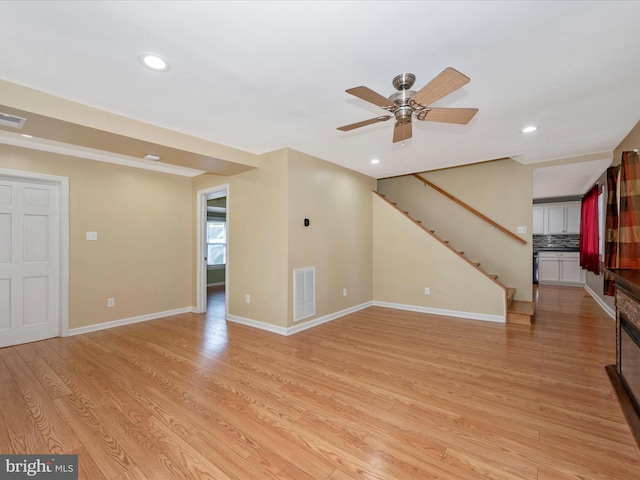 unfurnished living room featuring ceiling fan and light wood-type flooring