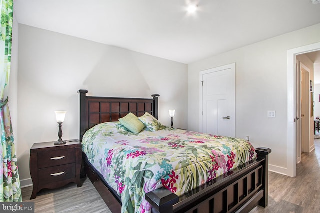 bedroom with baseboards and wood finished floors