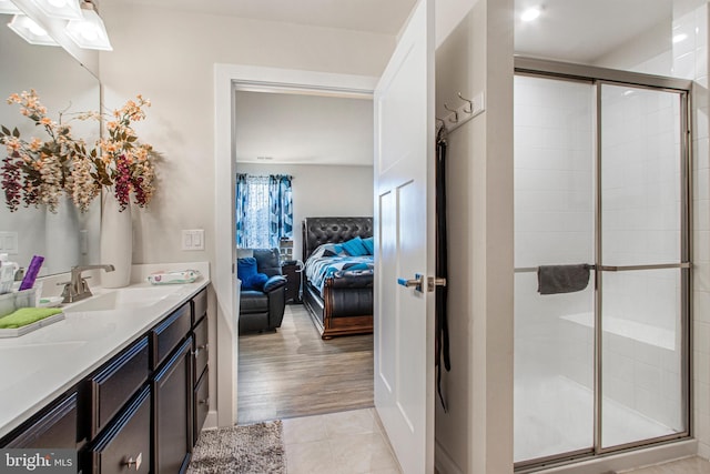 bathroom featuring a stall shower, ensuite bath, tile patterned floors, and vanity