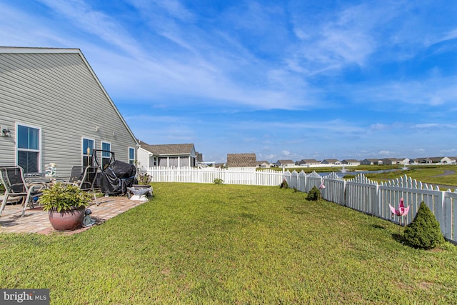 view of yard featuring a fenced backyard, a residential view, and a patio