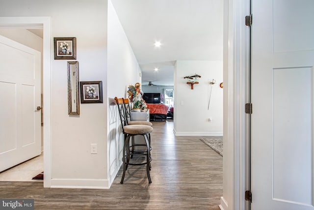 corridor with recessed lighting, baseboards, and wood finished floors