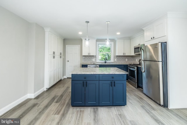 kitchen featuring pendant lighting, white cabinets, a kitchen island, appliances with stainless steel finishes, and blue cabinets