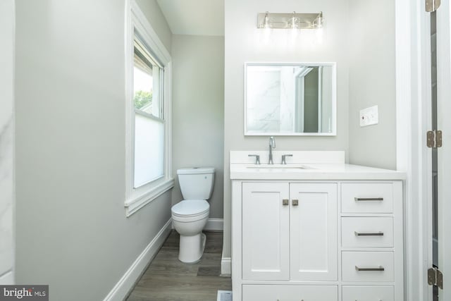 bathroom featuring wood-type flooring, vanity, and toilet