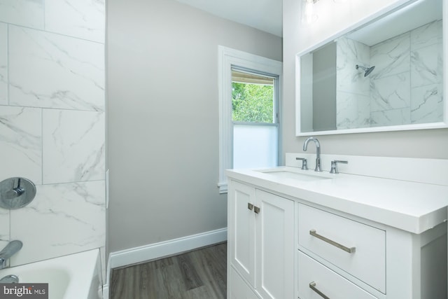 bathroom featuring tiled shower / bath combo, vanity, and hardwood / wood-style floors