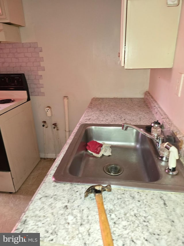 kitchen with electric stove and sink