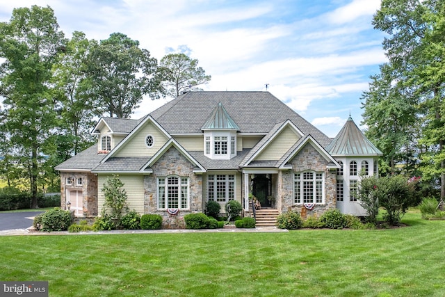 craftsman-style house with stone siding and a front lawn