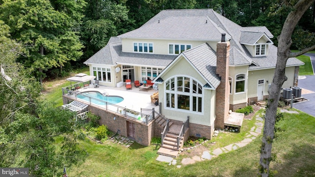 back of property featuring a chimney, a shingled roof, a lawn, crawl space, and an outdoor pool