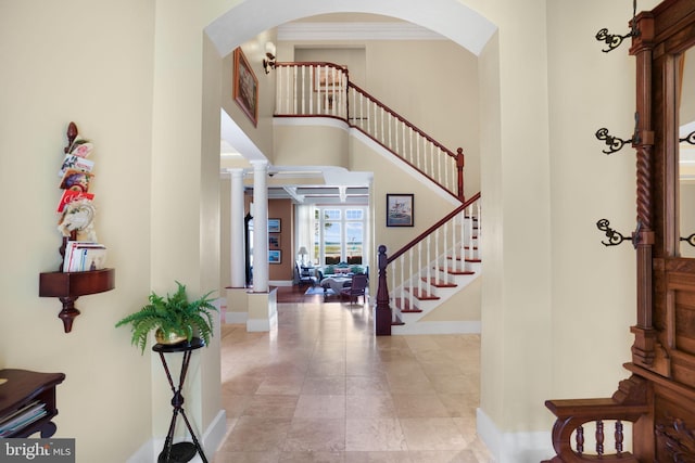 foyer entrance featuring stairway, a high ceiling, and baseboards