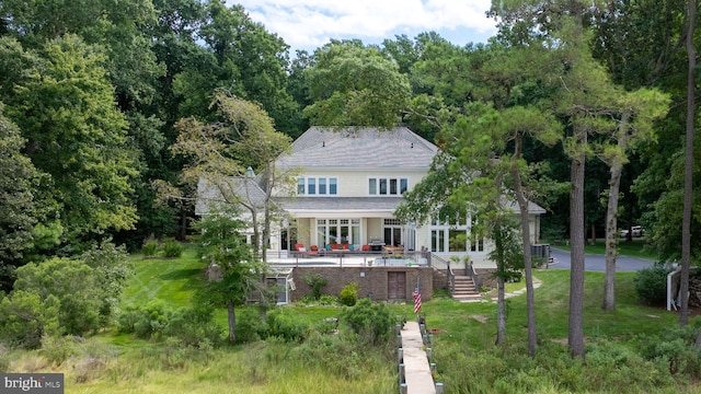 rear view of house with a patio, a lawn, an outdoor pool, and central air condition unit