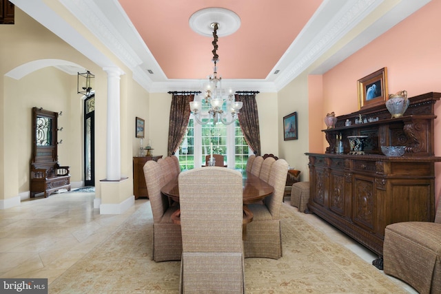 dining room featuring a chandelier, arched walkways, ornamental molding, and baseboards