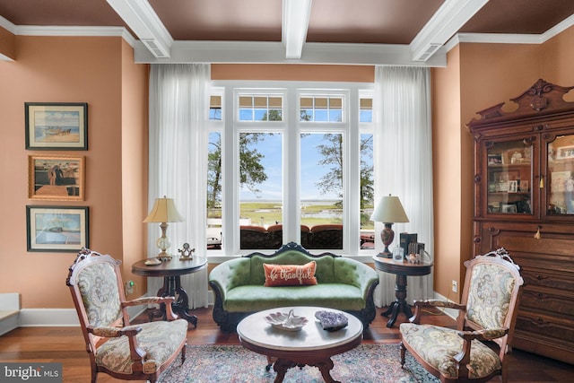 living area with baseboards, ornamental molding, beam ceiling, and wood finished floors