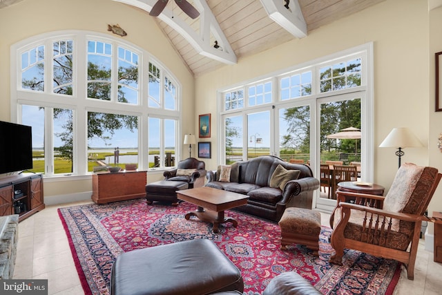 living area with beam ceiling, light tile patterned floors, ceiling fan, high vaulted ceiling, and wooden ceiling