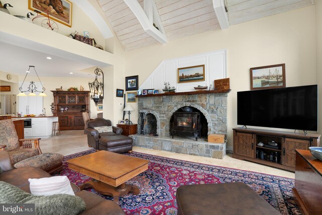 living area with high vaulted ceiling, beamed ceiling, wooden ceiling, and a wood stove