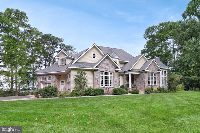 craftsman-style house with stone siding and a front lawn